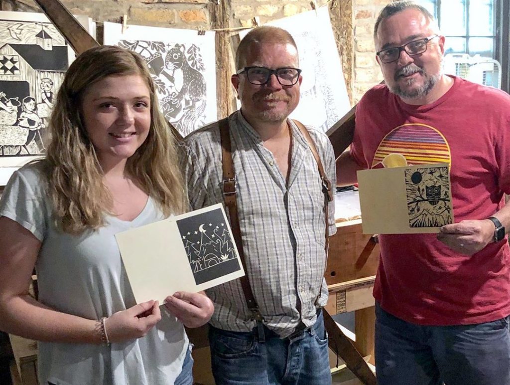 artist ken swinson with photographer, chuck moore and daughter at the log cabin print shop