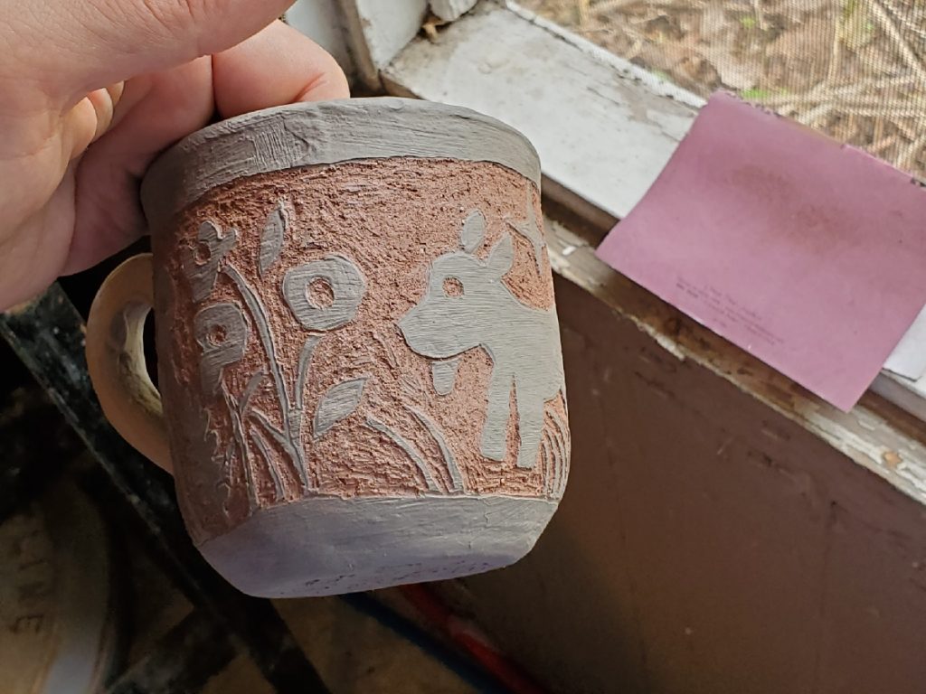 redware mug with flowers and a dog