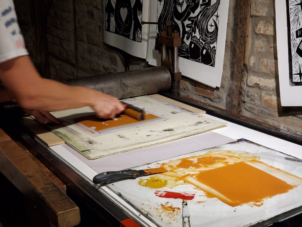 artist dustin cecil printing with orange ink
