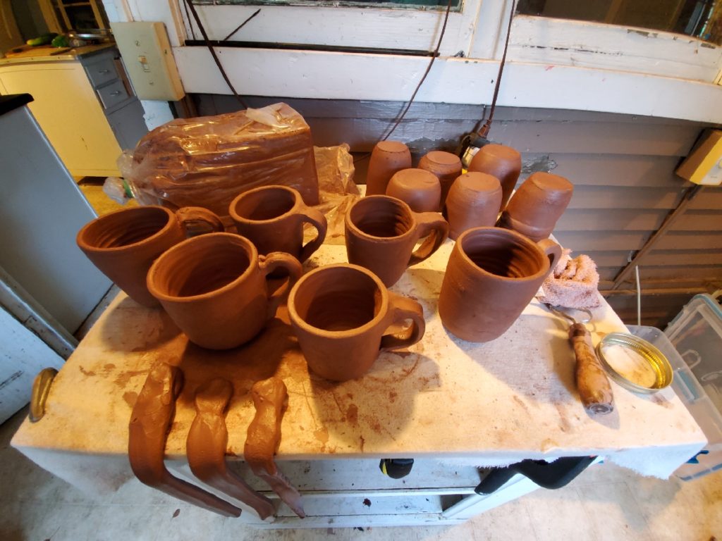 work in progress photo of redware mugs with handles