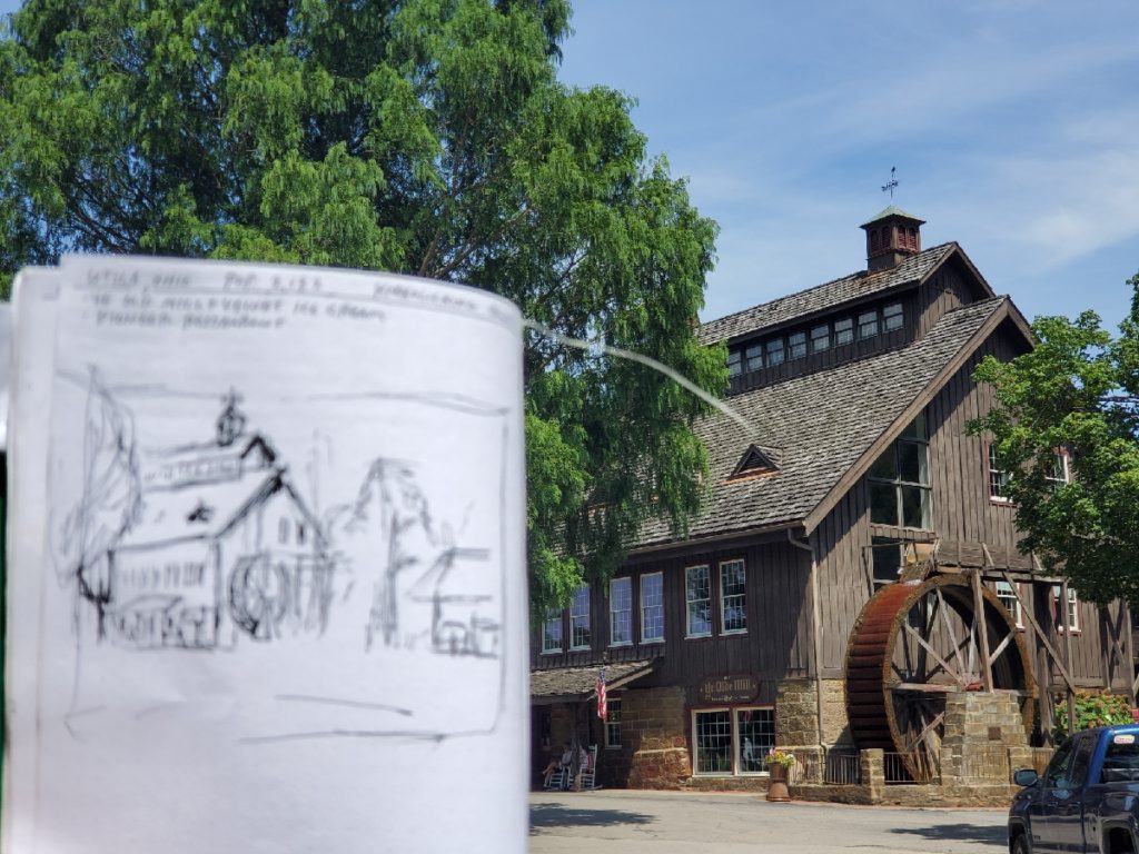 holding a sketch in front of ye olde mill in utica ohio
