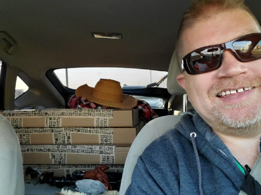 selfie style photo of ken the artist with a car loaded with paper