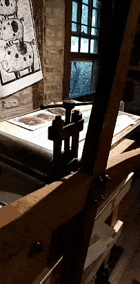 animated gif of a linocut being printed with a traditional press