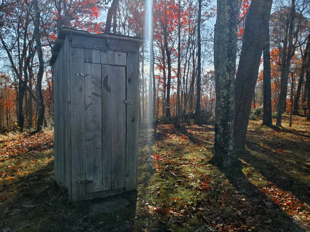 outhouse with moon painted on door at the poston schoolhouse museum in fleming county kentucky