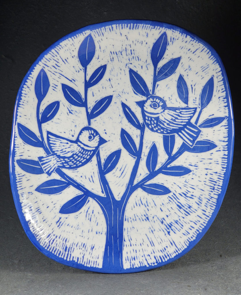 blue porcelain plate with folk art birds in tree design