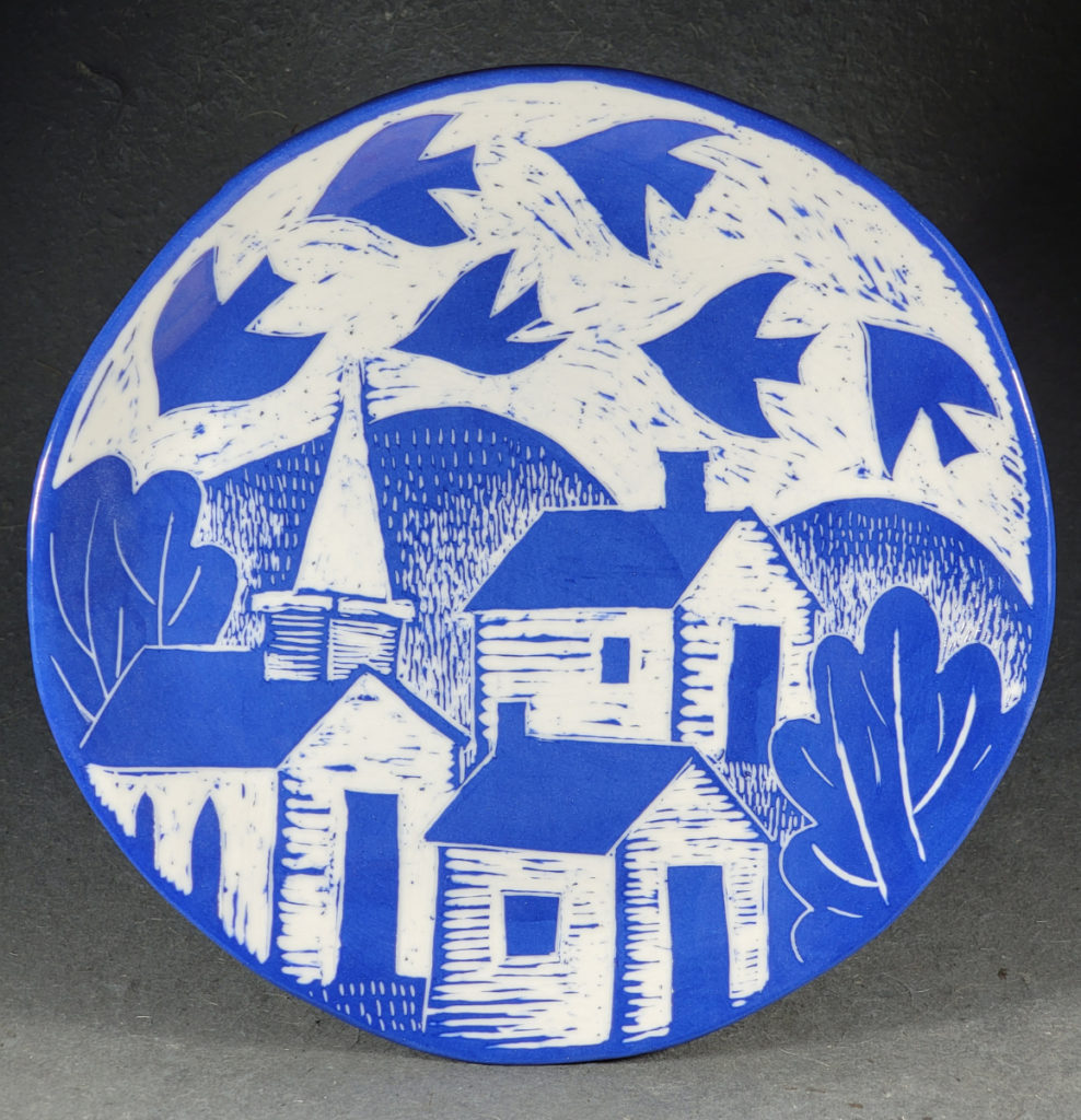 blue porcelain plate with village and flock of birds design