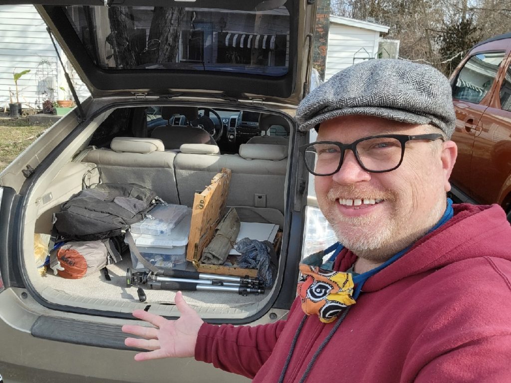 kentucky artist ken swinson smiling by car trunk filled with art supplies