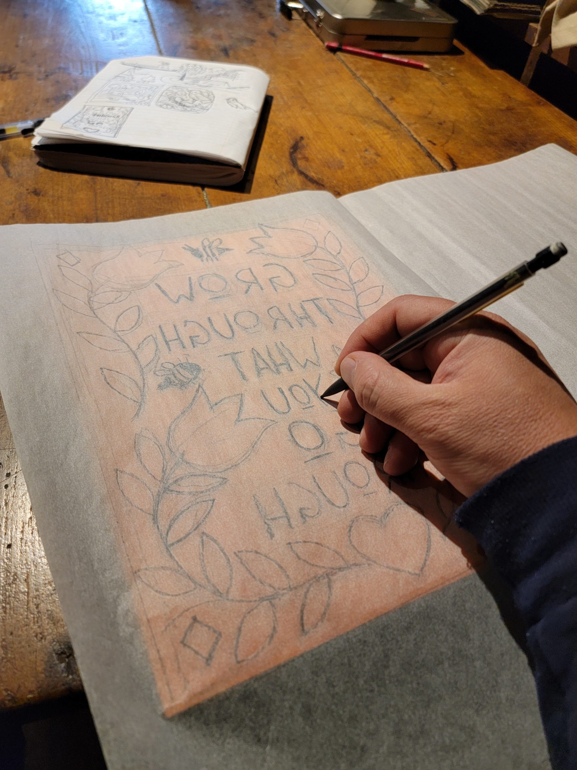 tracing design from paper to block of wood for woodcut printmaking