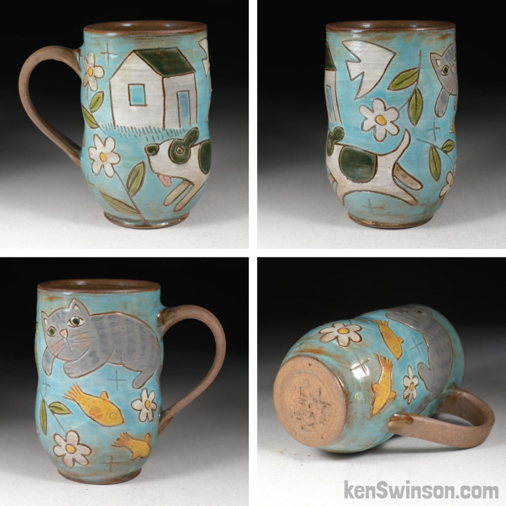 handmade stoneware cup decorated with a house, dog cat and fish surface design