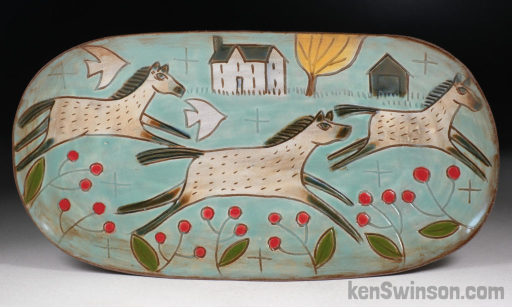 handmade stoneware plate in an oval shape decorated with 3 horses, a house and barn in the background