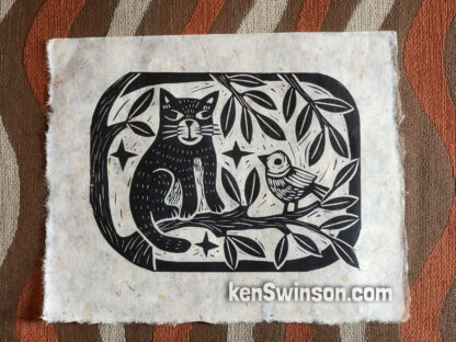 original linocut of a cat sitting on a tree branch with a bird