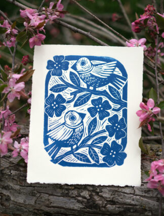 linocut print by kentucky artist, ken swinson. The image depicts a blue and white block print of two birds in a flowering tree.