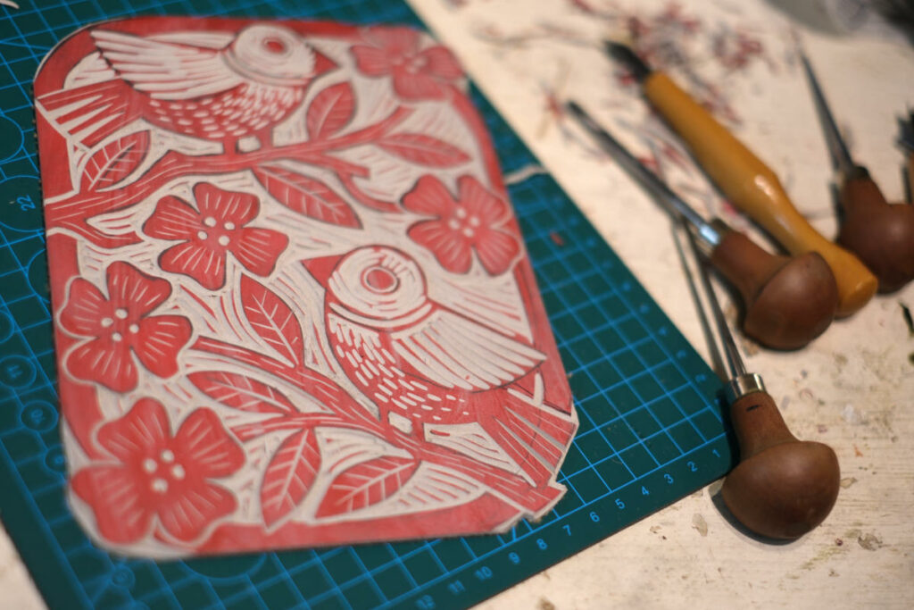 carved linocut of birds in a flowering tree. ready to ink