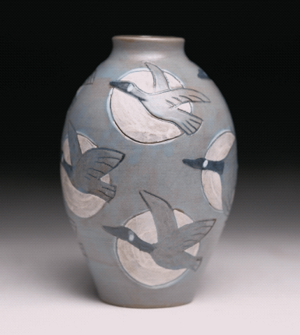 a pottery vase with canada geese decoration